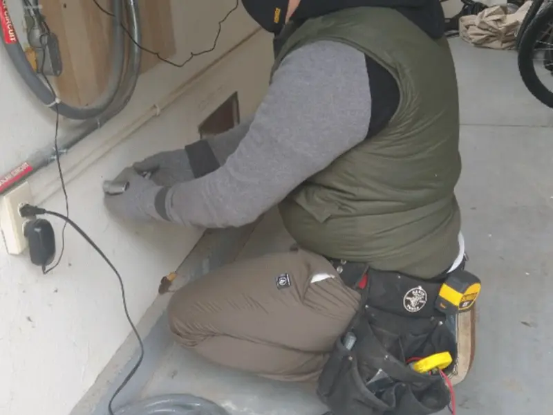 Electrician performing outlet wiring in a Essex garage